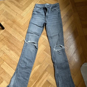Zara jeans grå - Säljes dessa jeans från zara med slitningar vid knäna samt en slit längst ner på benen. 