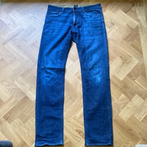 Blå jeans från Hugo Boss - Säljer ett par snygga blå jeans från Hugo Boss. De är i bra skick och har en klassisk femficksdesign. Jeansen har en normal passform och är tillverkade i ett hållbart material. Perfekta för både vardag och fest! jeansen storlek är 34/34 men passar bra på mig som är 181 och väger 75kg 