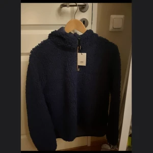 Marinblå fluffhoodie säljes i M - Marinblå fluffhoodie från crw, i storlek M säljes. Helt oanvänd med prislappen på😇. Nypris: 499 Mitt pris: 330 kr✨☺️