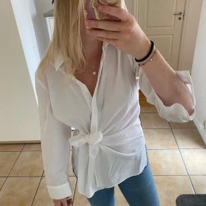 Vit skjorta/blus  - Vit skjorta med knytning i midjan. Aldrig använd. 