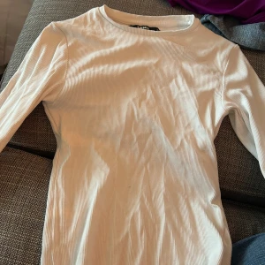Vit ribbad tröja från BikBok - Säljer en snygg vit ribbad tröja från BikBok i storlek XS. Tröjan är långärmad och perfekt för både vardag och fest. Den är i nyskick och väldigt bekväm att ha på sig. Passar bra till jeans eller kjol!