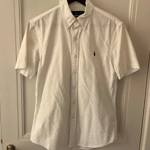 Ralph Lauren skjorta M - Kortärmad Ralph Lauren skjorta i färgen vit. Storlek M och väldigt fint skick. Köp för endast 299kr