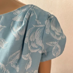 Aspens svenska sidenväveriet Rosor ljusblå vintage klänning, Rockabilly, 50-tal, 60-tal, retro - Behöver sys 5cm i slutet av dragkedjan. I övrigt inget att anmärka på.