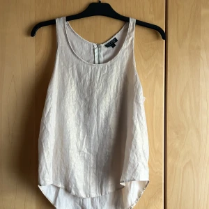 Fest topp/linne i lätt skimrande tyg - Fest/sommar topp i lätt skimmrande gyllene/creme vit tyg. Skön lätt tyg. Strl 38