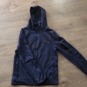 Nike tech fleece (Dark blue) - Säljer denna oanvända Nike tech fleece tröja/hoodie.  Skick-10/10 ser ut som ny! Storlek-XS/154-170 passar även S Köpare står för frakt kostnad.  Hör av er vid mer info eller frågor! 