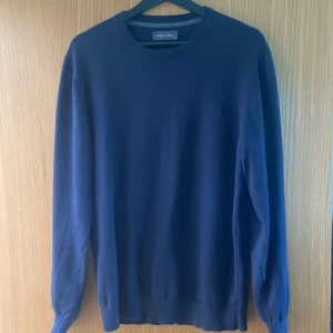 Mörkblå tunnt stickad tröja - Jag säljer min tunnt stickade mörblåa tröja från Emidio Tucci som endast kan köpas utomlands och är väldigt sällsynt märke. Den är i en cashmere mix och fint tunnt stickad. Tröjan är i  bra skick och pris kan diskuteras vid snabb affär.