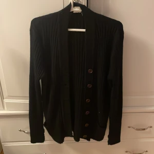 Kofta - En svart kofta med knappar och fickor
