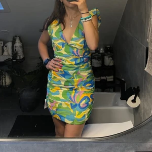 Mönstrad sommarklänning - Snygg mönstrad sommarklänning. Helt ny med lapp kvar. Verkligen jättesöt med fina detaljer på sidan och på ärmarna.