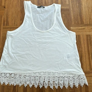 Spetstopp - Somrig och romantisk linne i 100 % bomull med spets nertill, knappt använt 