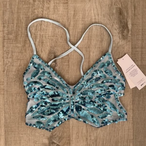 Paljett topp XS/S - Säljer denna blåa paljett topp i stl XS/S. Knytning ibak. Köpt från Gina tricot. Oanvänd, lappar kvar 