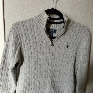 Polo Ralph lauren half zip -  Otroligt snygg grå polo Ralph Lauren halvnio i bra skick, storlek 14-16. Kabelstickad ny pris 1500.  Pris 600