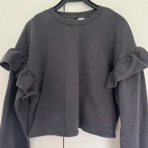 Grå tjocktröja - Grå tjocktröja med volanger på armarna🌟🌟 Bra skick☺️