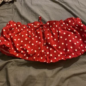 Prickig Topp - En väldigt fin, gullig, röd topp med vita prickar. Aldrig använd, bara testad så den inte passade mig.  Toppen är lagom stretchig. Har snöre längst mellan tuttarna som man kan knyta till rosett.