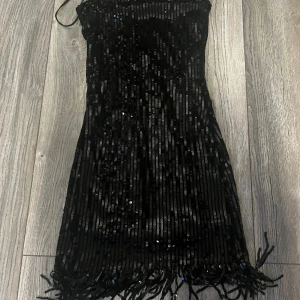 kort paljettklänning - Kort svart paljettklänning i storlek XS. Använd 1 gång och i bra skick. 