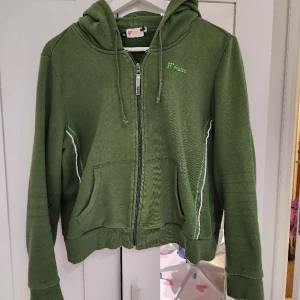 Grön croppad huvtröja i stl Xl  - Huvtröjan har använts 3 ggr, står att den är Xl men eftersom den är croppad så är den ganska liten. 