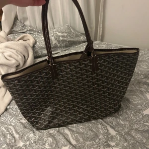 Goyard väska - Jag köpte denna väskan av en tjej här på plick men var mycket missnöjd då hon inte förklarade att väskan iprincip inte går att använda då den är sönder i handtagen som man ser i andra bilden. Därav säljer jag nu den och hoppas att någon ksk vill ha den:)
