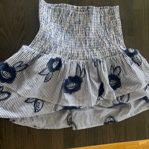 Volangkjol - Fin volangkjol från ”Holly & Whyte” Lindex. Super härlig till sommaren. Går att vika ner om man inte vill ha den högmidjad det har jag gjort på en av bilderna. Inga tecken på användning, skriv vid funderingar!🩷