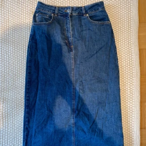 Jeanskjol - En jeanskjol i midilängd, slutar mitt på vaden. Skönt mjukt jeanstyg☺️