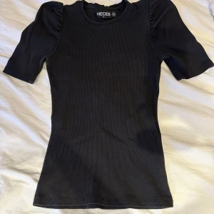 Tröja  - Svart kortärmad tröja från pieces, blev använd ca 1 år. Ribbad material. 