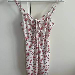 Superfin vit klänning med rosa blommor på, använd någon enstaka gång, mycket fint skick