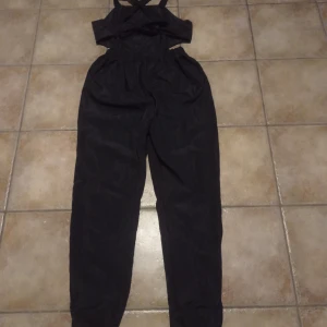 Jumpsuit Ny stl 38  - Nyinköpt samt oanvänd jumpsuit. Rygglös med korsande band på ryggen. Resår vid midjan ovanför rumpan.Den är något för lång för mig,är 158cm,så runt 160-170, antar jag att den sitter bra. Själv väger jag ca 62 kg.