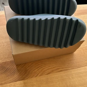 Yeezy slides storlek 42 - Helt nya Yeezy slides i storlek 42 herr säljes för 1300kr. Säljes på grund av fel storlek då jag har fått dem i present. Butikspris 2000kr.