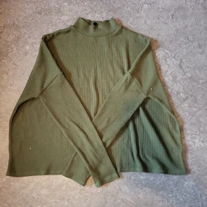 Fin grön lång crop top  - Grön turtleneck tunn crop top som passar perfekt till sommarkvällar. Har små hål på vänstra axeln som man märker knappt. 
