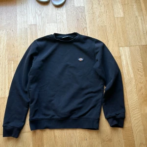 Svart dickies sweatshirt - En svart dickies sweatshirt i storlek xs med ett litet tryck vid vänstra sidan av bröstet. Använd ganska mycket med lite slitningar vid muddarna. Annars bra skick.  Nypris runt 600