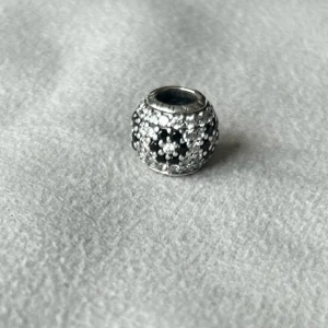 Pandora berlock  - Nästan oanvänd. Super fin med transparenta glittriga kristaller och en blomma från svarta stenar. Lite äldre Pandora kollektion.  Kostade 800 ny. 