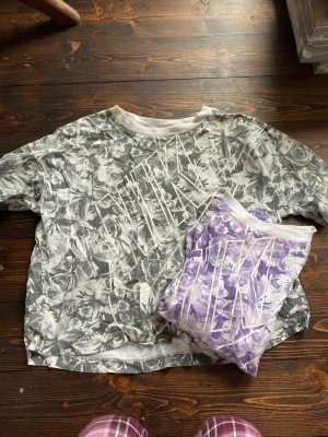 2 Nike T-shirts XS - Två stycken likadana T-shirts från Nike i fint skick. En lila och en grå med blommotiv. Oversize