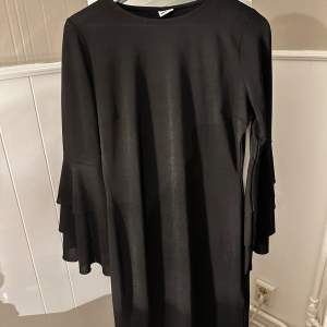 En jättefin svart klänning med volangärmar💓 Har aldrig använts och är i mycket bra skick🩷Den är i storlek L men passar som storlek M och möjligtvis storlek S💜