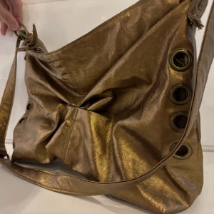Axelväska  - Guldig axelväska, bra med utrymme. Second hand köpt