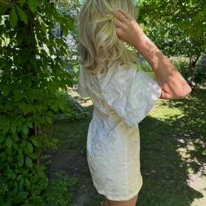 Mini klänning - Så fin sommarklänning i ny skick! Blommigt mönster och krämfärgad. Storlek är S men passar både M L beroende på hur man vill att den ska sitta på kroppen. 