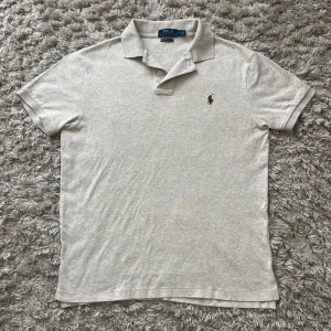 Ralph Lauren Piké - Asskön piké från Ralph lauren i lite tunnare material, snygg grå/beige färg och i storlek M. pris diskuterbart!
