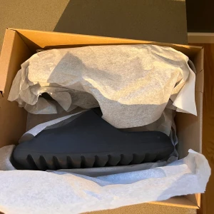 Yeezy Slide - Säljer då dom blivit för små. Storleken är 40,5 och sitter bra i storleken. Använda fåtalet gånger inomhus men är fortfarande i ett mycket bra skick 8/10. Säljes för 750 men priset är inte hugget i sten. Tveka inte om att fråga. Kvitto finns