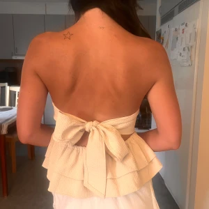 Bandau topp med öppen rygg - Jättefin axelbandslös topp med knyte som man knyter där bak! Aldrig använd ❤️