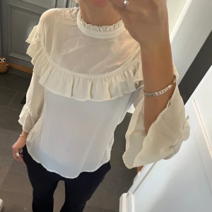 Vit blus med volanger  - Vit blus från Mbym med volanger i storlek M. Fint skick. Använd gärna köp nu!