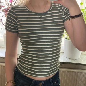 Super söt grönrandig T-shirt  - Jättegullig randig T-shirt i vitt och grönt med måtten 164-152 och är av viskos. Den är väldigt stretchig så den passar även större storlekar. 