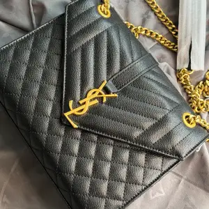 Säljer denna svarta Yves Saint Laurent väska med gulddetaljer. Medföljer dustbag och låda. Den är i nyskick utan defekter. Utgångspriset är 3000kr men går att diskuteras vid snabb affär. 1:1