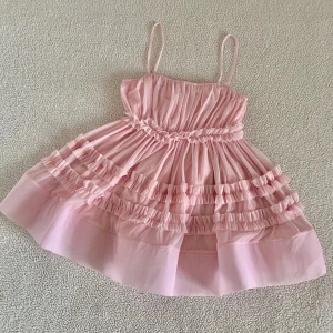 ZARA babyrosa miniklänning i tyll med volanger - Otroligt vacker volangklänning från ZARA i tyll med volym. Aldrig använd, i nyskick utan anmärkningar. Har tagit av tags när jag provat den. 