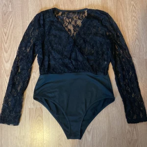 Bodysuit med spets - Tänkte sälja min body, då jag bara använt den en gång och insåg att den inte riktigt var min grej. Hela överdelen är spets medans underdelen är ett mer lent tyg. Framsidan är lite genomskinlig men inte för mycket, medans ryggen är nästan helt.