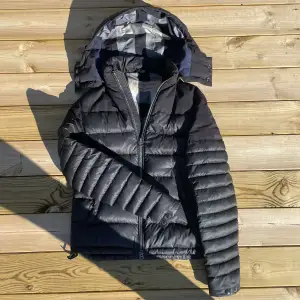 Grymt fet tunnare Burberry dunjacka, perfekt för vår och kalla sommardagar. Luvan gör allt. En lagning på sista bilden. Nypriset ligger på ca 10000kr. Allt gott, mvh Wilmer