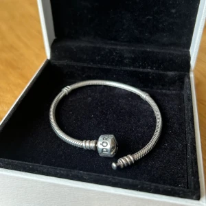 Pandora Moments rmband storlek 17 - Pandora armband som inte kommer till anändning. Nyligen putsat och är i jättebra skick. Storlek 17. Asken medföljer.  Ny kostar 649 sek