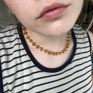 Halsband  - Vackert halsband med fina bärnstensfärgade glaspärlor. 