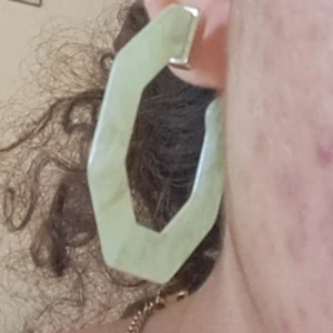 Gröna örhängen i geometrisk form - Ett par gröna örhängen i en unik geometrisk form. Örhängena har en ljusgrön färg med en marmorerad effekt och är fästa med en silverfärgad stift.