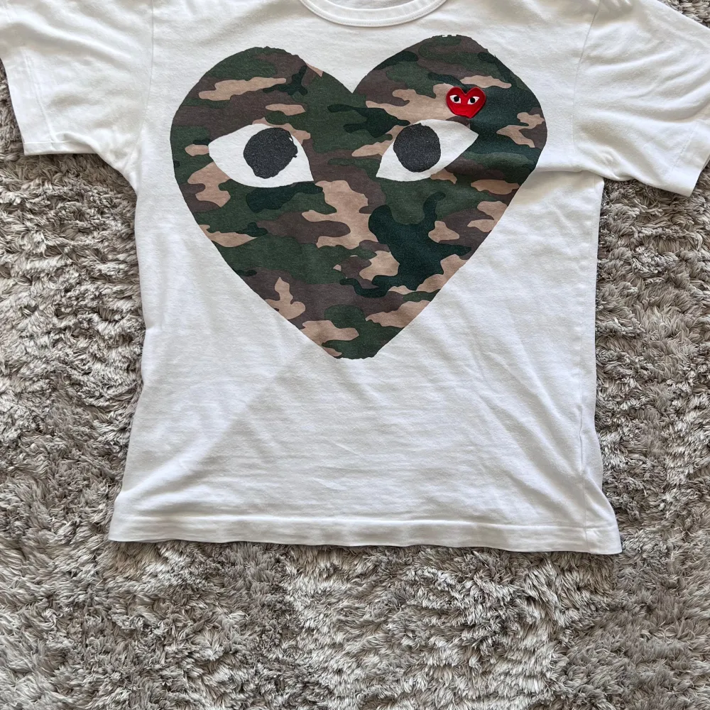 Eftertraktad comme des garçons t-shirt. Köpt här på plick. Cond 8/10. Priset är fast. Hör av dig vid mer frågor ✌🏻. T-shirts.