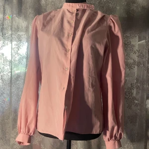 Rosa blus - En fin rosa blus köpt från myrorna i Järntorget. Märket är lillygould of London och är gjord i England.  Storleken är 16 GB vilket jag tror är ca 40 i svensk storlek. Men passar mig som är 38 