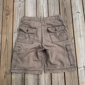 Levis cargo jorts - Levis workwear som är köpta begangnade och inte används längre för att dem e för små. De har två cargo fickor och dem vanliga fyra fickorna. Skriv om ni har fler frågor eller om ni vill ha fler bilder!!