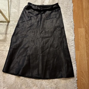 Satin kjol - Materialet gör sig inte på bild, men en satin kjol som går över knäna.