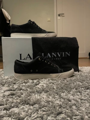 Svarta sneakers från Lanvin i mocka - Säljer ett par svarta Lanvin sneakers med glansig tå. Helt äkta och kommer med original box och dustbag 